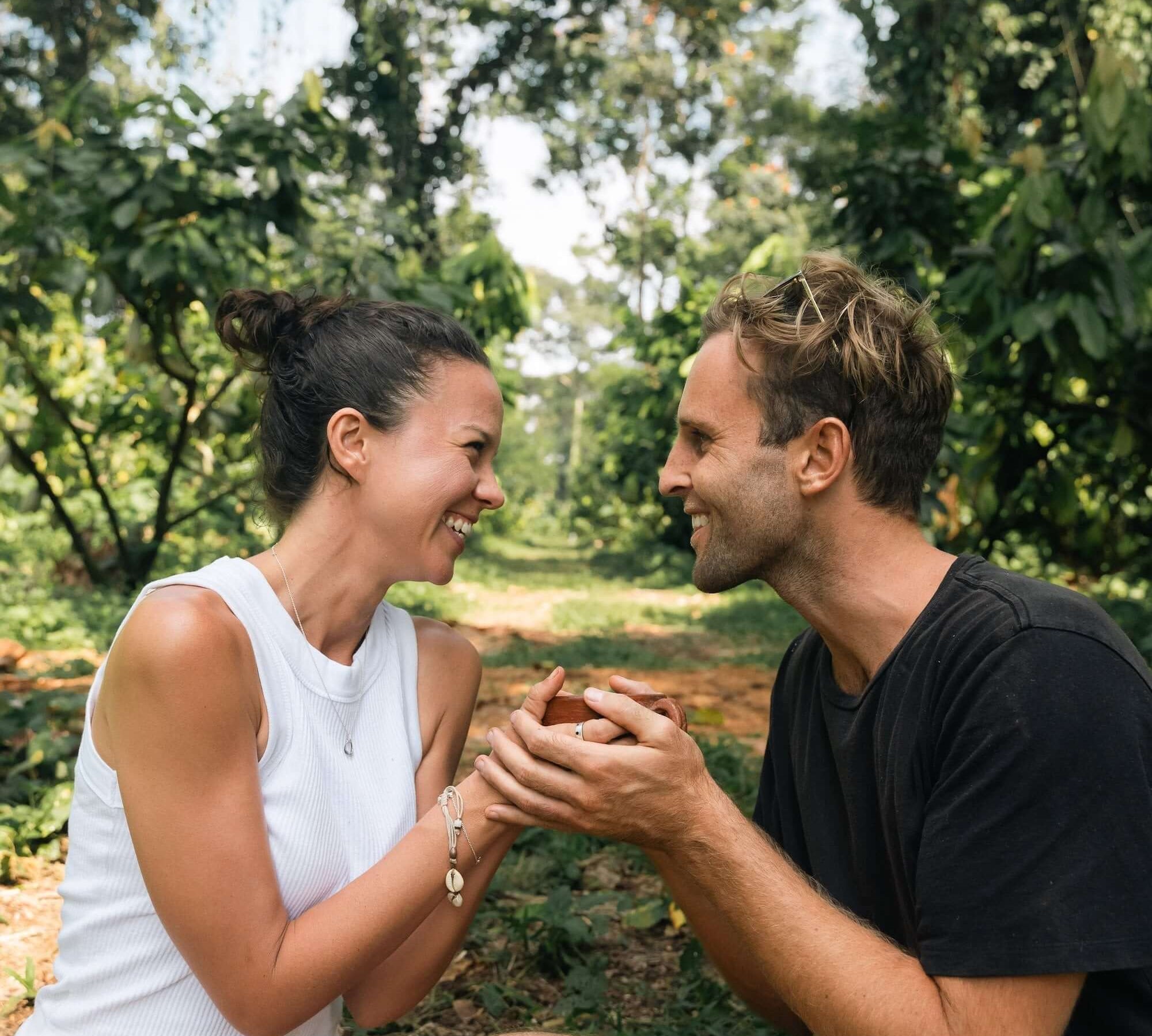 Couple enjoying cacao in a lush forest, highlighting the connection with ceremonial cacao.