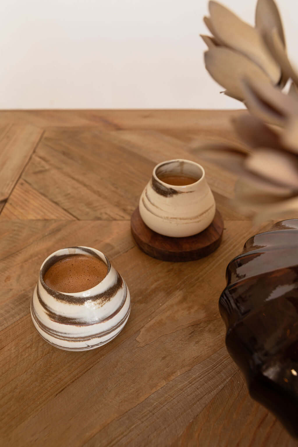 Two ceramic cups filled with ceremonial cacao on a wooden table, emphasizing cacao's rich flavors and health benefits.