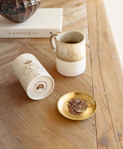 Daintree Cacao Tea with Brass Tea Scoop on wooden table, highlighting ceremonial cacao drink and health benefits.