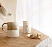 Daintree Cacao Tea and Brass Scoop next to a steaming mug for a ceremonial cacao experience.